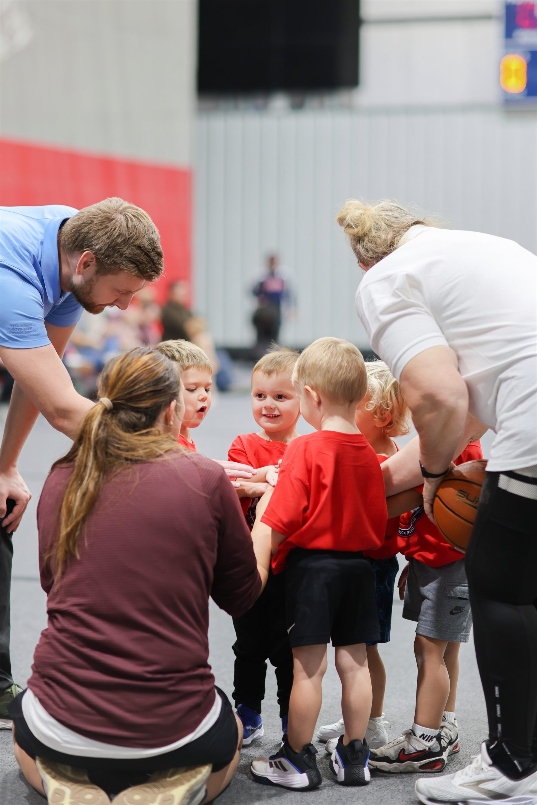 Coaches talking with young basketball players in a huddle